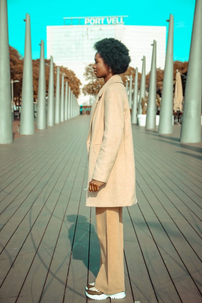 side view of a woman in beige coat and khaki trouser
